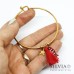 Bracciale bangle in acciaio color oro con ciondolo pesce e nappina