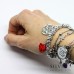 Bracciale a tema Alice con nodini intrecciati in alluminio e charms