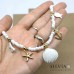 Collana girocollo corallini bianchi con conchiglia e charms mare oro e bianchi